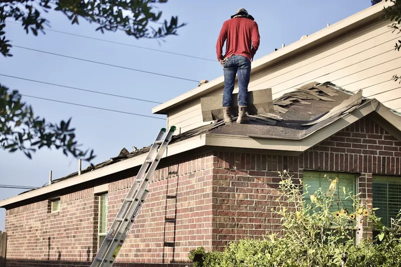 Professional roofer working on a residential roof in Park Village